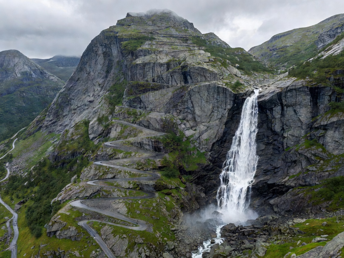 Dramatic hairpin turns of Trollstigen ascending steep alpine valley wall next to Stigfossen waterfall